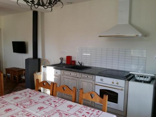 Il comprend une cuisine équipée d'une cuisinière, d'un évier et d'une table. dans l'établissement Au gite Dolois, à Dole