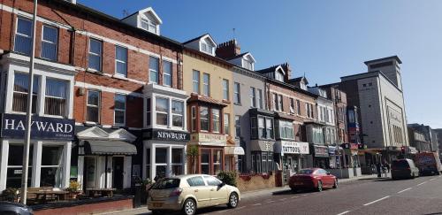 a city street with buildings and a car parked on the street at Hayward Hotel in Blackpool