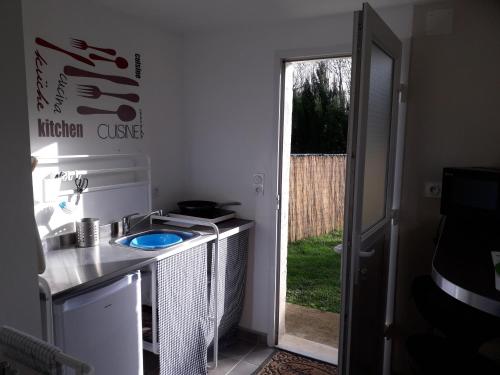 a kitchen with a sink and a door to a yard at Maison de la Gare in Tombeboeuf