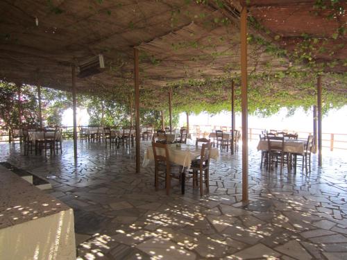 a restaurant with tables and chairs under a pavilion at Sfinias Apartments in Kali Limenes