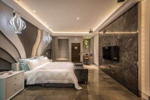 una camera con un grande letto e una TV di Green Palm Motel a Yuanlin