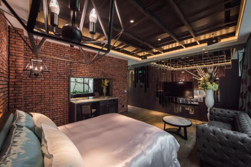 a bedroom with a bed and a couch and a television at Green Palm Motel in Yuanlin