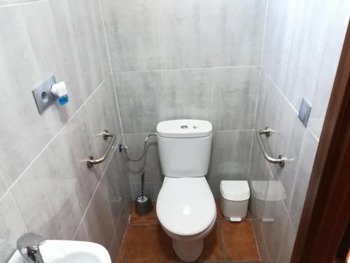a bathroom with a white toilet and a sink at Cueva Tradicional El capricho in Guadix