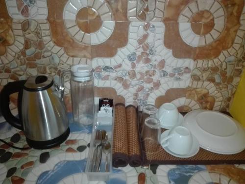 a table topped with plates and cups and a coffee pot at Casa Mirasol in Siquijor