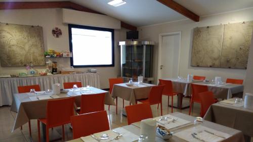 um restaurante com mesas e cadeiras e uma grande janela em ALBERGO METAURO em Fano