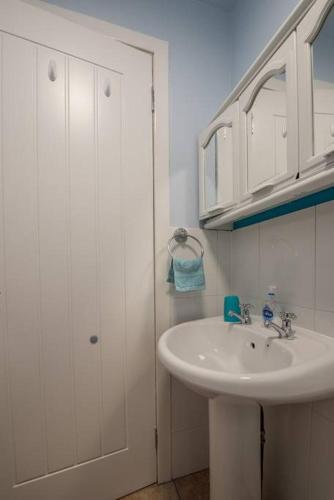 a white bathroom with a sink and a shower at Brucefield Avenue, Dunfermline in Dunfermline