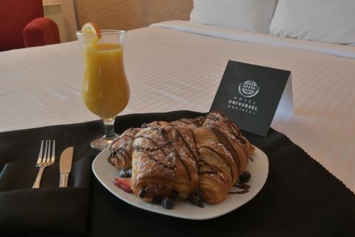 a plate of food on a table with a glass of orange juice at Hotel Universel Montréal in Montréal