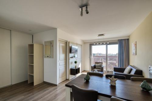 a living room with a table and a dining room at Evancy Etoile Des Dunes in Bray-Dunes