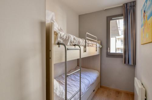 two bunk beds in a room with a window at Evancy Etoile Des Dunes in Bray-Dunes