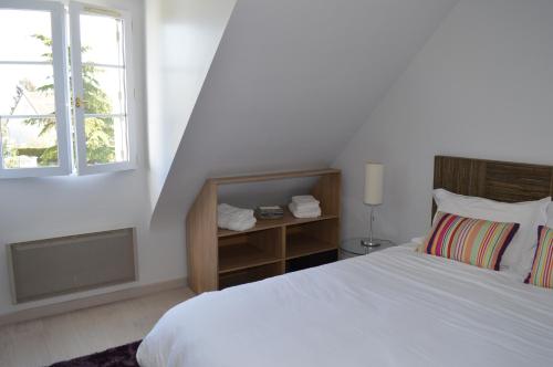 Le Clos du Vieux Port في Véretz: غرفة نوم بيضاء بها سرير ونافذة