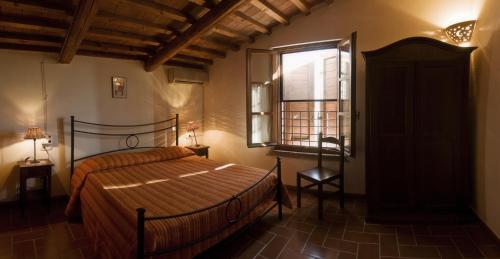 - une chambre avec un grand lit et une fenêtre dans l'établissement Agriturismo Il Melograno di Banditella, à Alberese