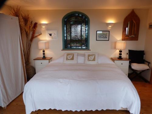 a bedroom with a large white bed with two pillows at Sunset Lodge in Kingsbridge