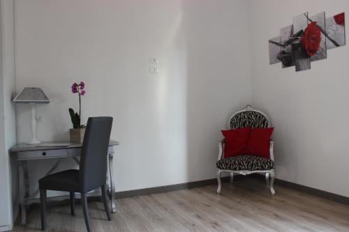a room with a desk and two chairs and a red pillow at Residenza Guglielmo in Mantova