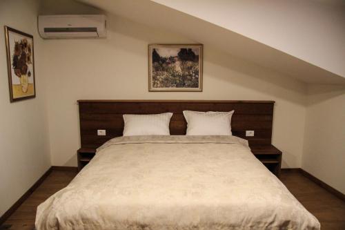 a bedroom with a large bed with two pillows at B&B Villa Panuka in Pančevo