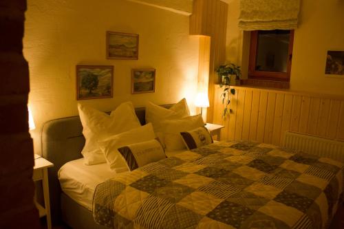 una camera da letto con un letto con cuscini bianchi di An den Elbwiesen Gästezimmer "Weißstorch" Nur Nichtraucher a Greudnitz
