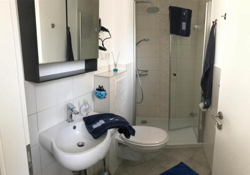 a bathroom with a sink and a toilet and a shower at Ferienhaus Edda in Timmendorfer Strand