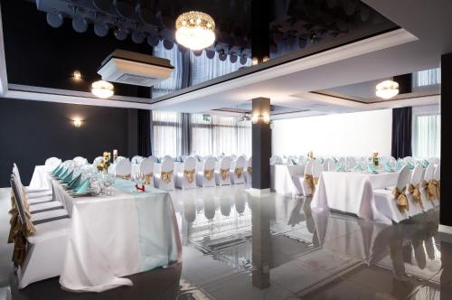 a banquet hall with white tables and white chairs at Willa Pieńkowskich in Gdynia