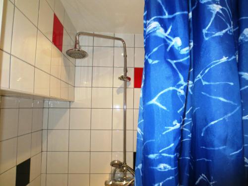 a bathroom with a shower with a blue shower curtain at Hostel Bed & Breakfast in Stockholm