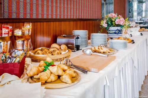 a long table with plates and baskets of bread at RHI Porta Bologna in Pieve di Cento
