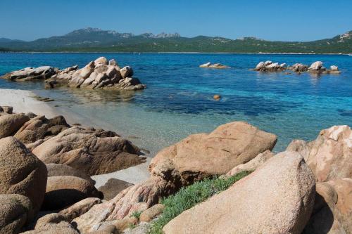 a group of rocks in the water near the shore at Hotel Il Piccolo Golf in Porto Cervo