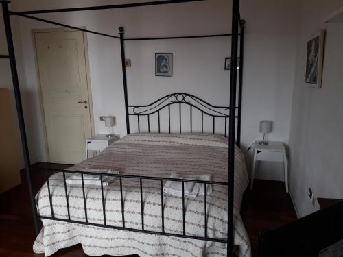 a bed with a white bedspread and a wooden headboard at Al Sandalyon in Quartu SantʼElena