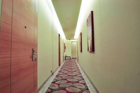 a corridor of a hallway with a rug on the floor at Middleton Inn in Kolkata