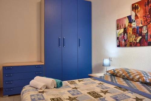 カーラゴノネにあるカーサ グステゥイのベッドルーム(青いキャビネット、ベッド付)