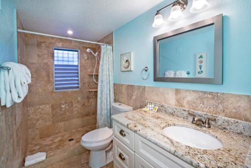 a bathroom with a sink and a toilet and a mirror at Secret Harbour Beach Resort in St Thomas