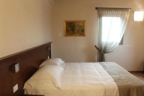 a bedroom with a white bed and a window at Agriturismo Ben Ti Voglio in Bologna