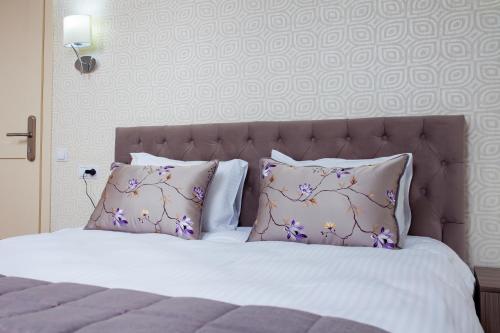 a bedroom with a bed with two pillows and a sqor at Familion ApartHotel in Chişinău