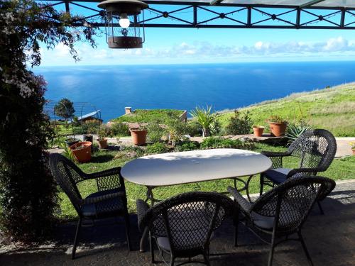 a table and chairs with a view of the water at Au petit Madère in Prazeres