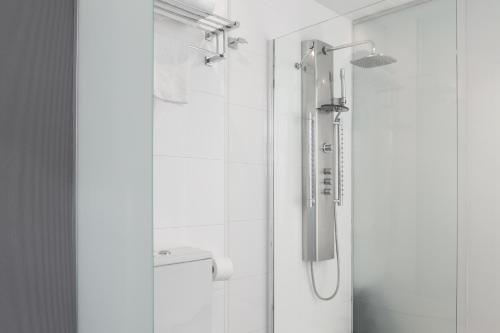 a shower with a shower head in a bathroom at Petit Palace Alcalá in Madrid