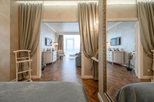 a bedroom with a mirror and a living room at ArnautSky in Odesa