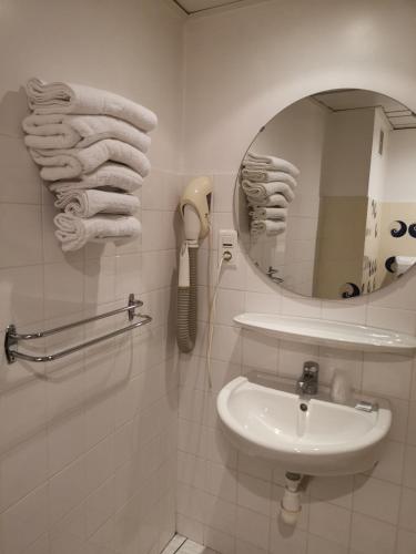 La salle de bains est pourvue d'un lavabo, d'un téléphone et d'un miroir. dans l'établissement Adonis Lourdes - Notre Dame de la Sarte, à Lourdes