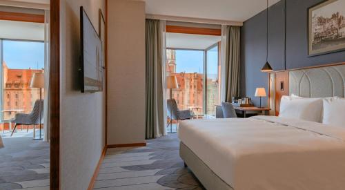 a hotel room with a bed and a view of a city at Radisson Hotel & Apartments Gdansk in Gdańsk