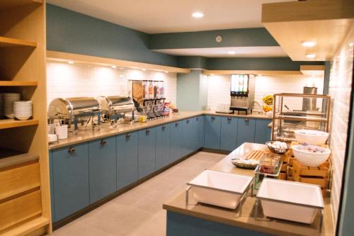 a large kitchen with blue cabinets and counters at Country Inn & Suites by Radisson, Erie, PA in Erie