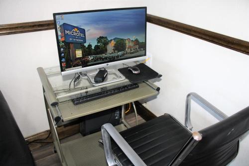 a computer desk with a monitor and keyboard at Microtel Inn by Wyndham Atlanta Airport in Atlanta
