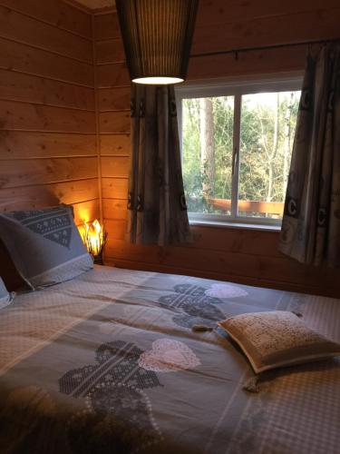a bedroom with a large bed with a window at CHALET MAAIKE in Durbuy