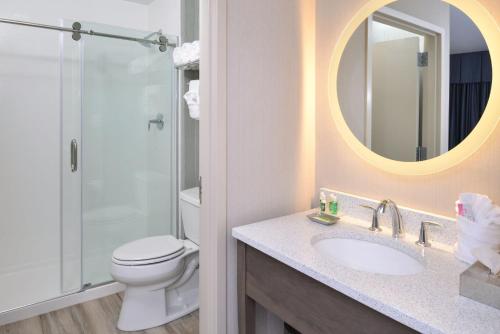 a bathroom with a toilet and a sink and a mirror at Anchored Inn at Hidden Harbor in Deale