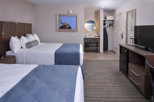 a hotel room with two beds and a flat screen tv at Anchored Inn at Hidden Harbor in Deale