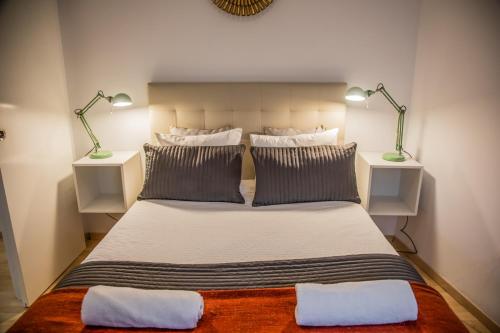 1 dormitorio con 1 cama grande y 2 lámparas en Bordador Bicycle City Center by Valcambre, en Sevilla