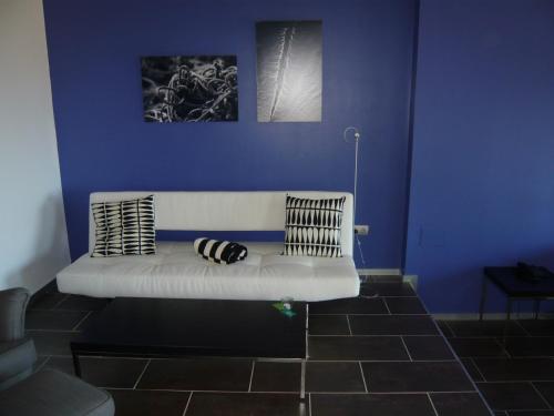 a blue wall with a white couch in a room at Mazagonia in Mazagón
