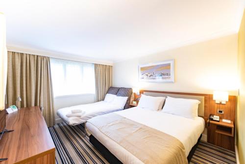 a bedroom with a large bed and a large window at Holiday Inn Cardiff North M4 Jct 32, an IHG Hotel in Cardiff