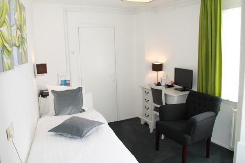 a bedroom with a bed and a chair and a desk at De Doelen in Leiden
