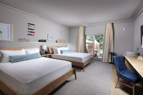 ファームビルにあるHotel Weyanokeのベッド2台とデスクが備わるホテルルームです。