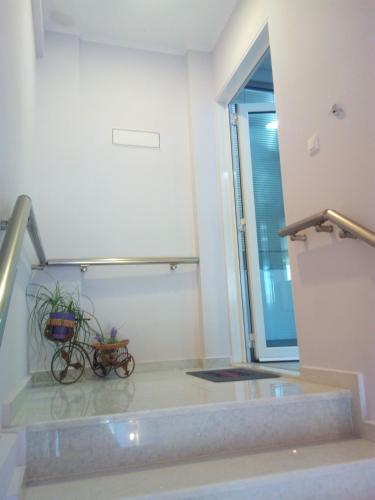 a room with a staircase with a bike in it at Cozy apartment near to the airport in Kouvarás
