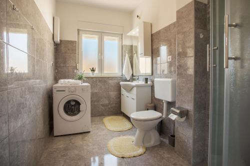 a bathroom with a toilet and a washing machine at Apartment Blaž in Split
