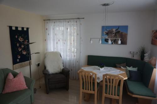 a living room with a table and a chair at Apartment Regina in Burgberg