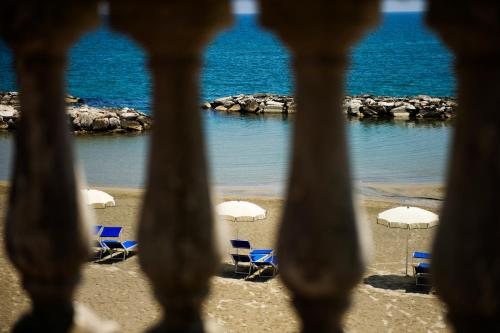 a view of a beach with chairs and umbrellas at Grande Albergo Miramare in Formia