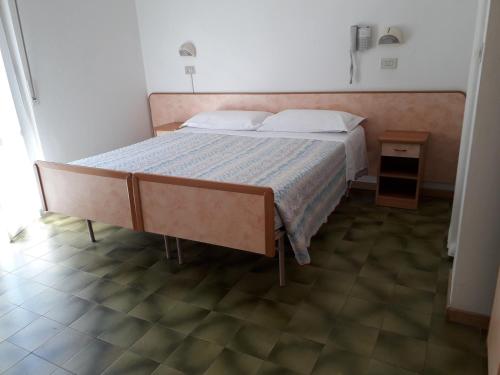 a bedroom with a large bed with a wooden headboard at Hotel Lora in Rimini